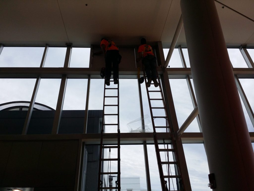 Guys safely installing film in Terminal F Philadelphia Int Airport